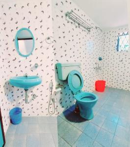 a bathroom with a blue toilet and a sink at Villa Sea Walk 5 BHK Villa in Candolim +39 photos