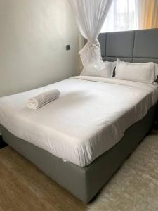 1bedroom@Pacho0725913803 في كيزيمو: سرير بشرشف ووسائد بيضاء في الغرفة
