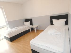 魏登的住宿－SUNNYHOME Monteurwohnungen und Apartments in Weiden，一间设有两张床和一张桌子的房间