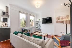 a living room with two couches and a tv at Kew Village- Modern Pets Welcome 3Bed in Richmond upon Thames