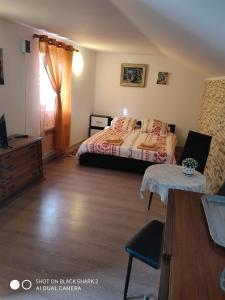 a bedroom with a bed and a dresser and a table at Casa Gheorghe in Balabancea