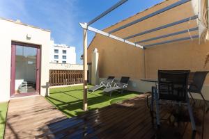 Un patio con sillas y una mesa en una terraza. en La Casa de la Alameda, en Málaga
