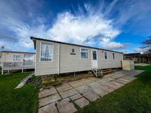 a mobile home on a patio in a yard at Lovely Caravan At Manor Park, Nearby Hunstanton Beach In Norfolk Ref 23067s in Hunstanton