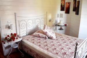 a bedroom with a white bed with pillows and a table at Villa Ceirano in Lagnasco