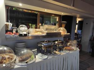 uma linha de buffet com comida em cúpulas de vidro em Hotel Byron em Atenas