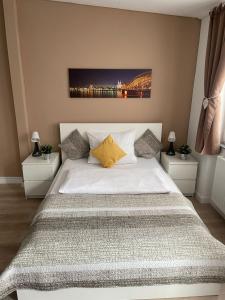 a bedroom with a large white bed with two night stands at FlatDeCologne CityPerle in Cologne
