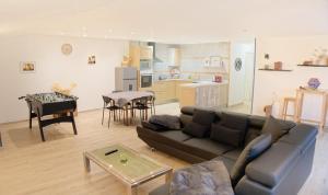 a living room and kitchen with a couch and a table at Chalet en pleine nature Pomerol in Pomerol