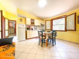 - une cuisine et une salle à manger avec une table et des chaises dans l'établissement Torre di Chia Holiday Home, à Chia