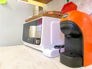 - un comptoir de cuisine avec une cafetière à côté d'un four micro-ondes dans l'établissement Torre di Chia Holiday Home, à Chia