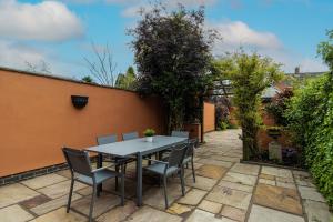 a patio with a table and chairs in a garden at Ellistown Retreat in Hugglescote