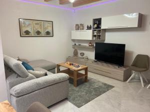een woonkamer met een bank en een flatscreen-tv bij Casa del pittore in Niscemi