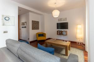 una sala de estar con un sofá y una mesa en La Casa de la Alameda, en Málaga