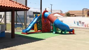 een speeltuin met een glijbaan in een park bij Resort Saúde Premium in Peruíbe