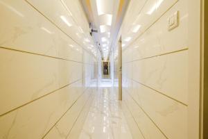 a hallway of a building with white marble walls at FabExpress Ashoka Inn in Mumbai