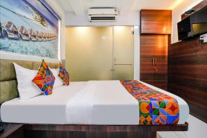 een slaapkamer met een groot bed en een kast bij FabExpress Ashoka Inn in Mumbai