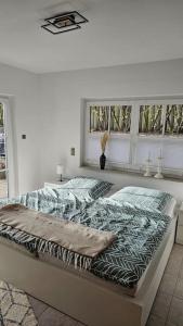 Ce lit se trouve dans un dortoir blanc doté de 2 fenêtres. dans l'établissement Ostseestern-Rügen 80m² Ferienwohnung Sassnitz, à Sassnitz