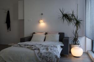 a bedroom with a bed and a potted plant at Sunny Mokotow - apartment near the metro in Warsaw