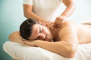 a woman giving a man a back massage at קסם עין כרם in ‘En Kerem