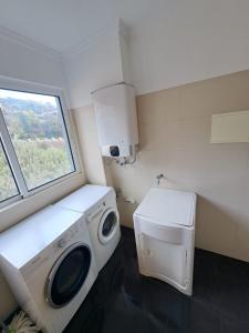 a laundry room with a washing machine and a window at NICE and MODERN FLAT NEAR AIRPORT in Santa Cruz