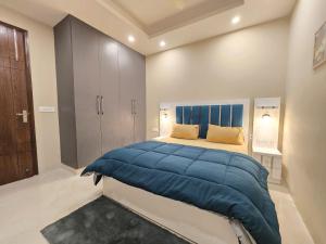 een slaapkamer met een groot bed en een blauwe deken bij Homlee-Saket Anupam Stylish 3BHK in South Delhi in New Delhi