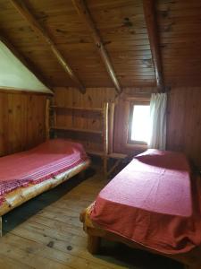 a bedroom with two beds in a log cabin at Alma de Puelo in Lago Puelo