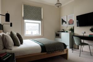 a bedroom with a bed and a desk and a television at Brayford House Carholme Road - Serviced Accommodation in Lincoln for Contractors, Business & Leisure Stays in Lincoln