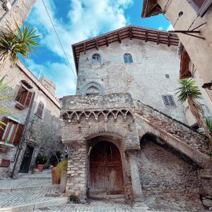 un antico edificio in pietra con una grande porta in legno di Maison Frida • Tivoli a Tivoli