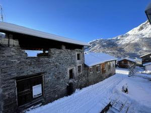 un hombre parado fuera de un edificio en la nieve en Chalet Aster - 4 Pièces pour 6 Personnes 444 en Saint-Marcel