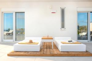 a living room with two white couches and a table at Delfini Villas 1, 2, 3, 4, 5, 6 - Kalamaki in Kalamaki