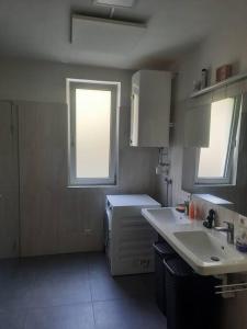 una pequeña cocina con fregadero y ventana en Quiet Room with shared kitchen bathroom, en Graz