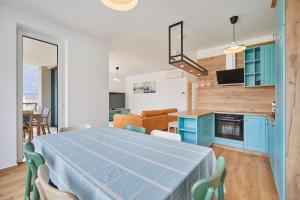 Il dispose d'une cuisine et d'un salon avec une table et des chaises bleues. dans l'établissement Apartments Svitnjak, à Bovec