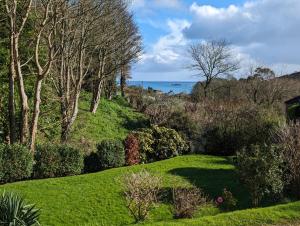 a garden with a view of the ocean at Mariners Rest in Gorran Haven