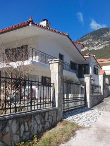 a white house with a wrought iron fence at Fani Apartment in Skotiní