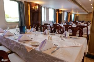 uma sala de jantar com uma mesa com copos e guardanapos em M/S Nile Quest Cruise - 4 or 7 Nights From Luxor each Monday and 3 or 7 Nights From Aswan each Friday em Luxor