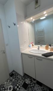 La salle de bains est pourvue d'un lavabo blanc et d'un miroir. dans l'établissement Appart'Hotel - Gare TGV - Courtine - Confluence - 218, à Avignon
