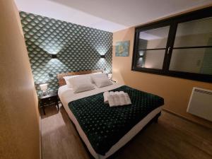 a bedroom with a bed with two pillows on it at Maison cosy La Petite Cigogne en Baie de Somme in Boismont