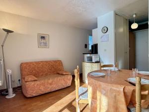 een woonkamer met een tafel en een stoel bij Appartement Argelès-sur-Mer, 1 pièce, 3 personnes - FR-1-225-634 in Argelès-sur-Mer
