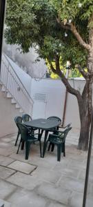 un tavolo da picnic e due sedie accanto a un albero di Casa Scarciglia a Minervino di Lecce