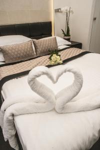 two towels in the shape of a heart on a bed at 39 Studios in London