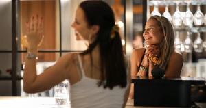 una mujer sentada en un bar hablando con otra mujer en Clarion Hotel Post en Gotemburgo
