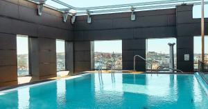 a large swimming pool in a building with windows at Clarion Hotel Post in Gothenburg