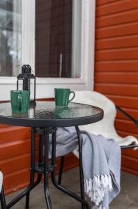 due tazze di caffè verdi sedute su un tavolo sotto un portico di Kesäelo a Porvoo