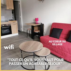 un soggiorno con divano rosso e tavolo di le cosy du beau lieu immozen 46 a Beaulieu-sur-Dordogne