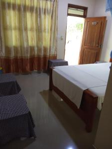 a bedroom with a bed and two chairs and a window at Udesh Guest in Polonnaruwa