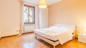 sypialnia z dużym białym łóżkiem w pokoju w obiekcie Villa Quantum - Italian Homing w mieście Desenzano del Garda