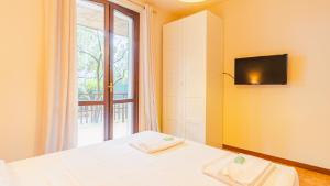 sypialnia z łóżkiem, oknem i telewizorem w obiekcie Villa Quantum - Italian Homing w mieście Desenzano del Garda