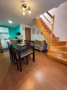 a living room with a table and chairs and a staircase at Departamentos NuBe1 Castro Chiloé in Castro