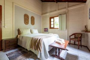 um quarto com uma cama, uma mesa e uma janela em Casa Águas Encantadas - Cachoeira e Águas termais em Santo Amaro da Imperatriz
