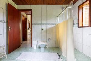 uma casa de banho com um WC e um chuveiro em Sítio Águas Encantadas - Cachoeira e Águas termais em Santo Amaro da Imperatriz