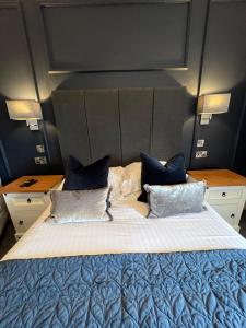 a bedroom with a large bed with blue pillows at Chapel Cross Guesthouse in Roslin